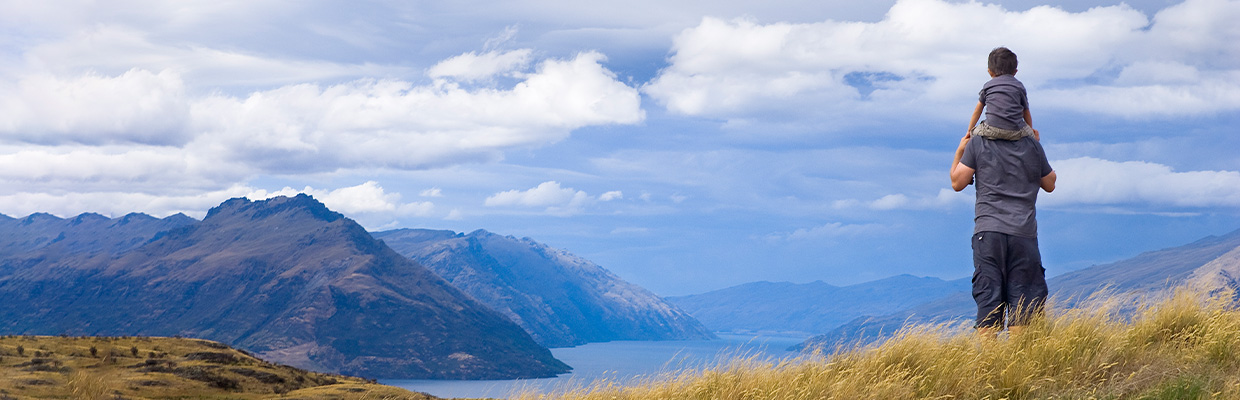 Father and son look out on the top of the mountain，image is used for deposits