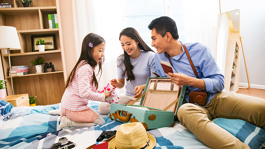 Parents and daughter packing up luggage, ready to travel