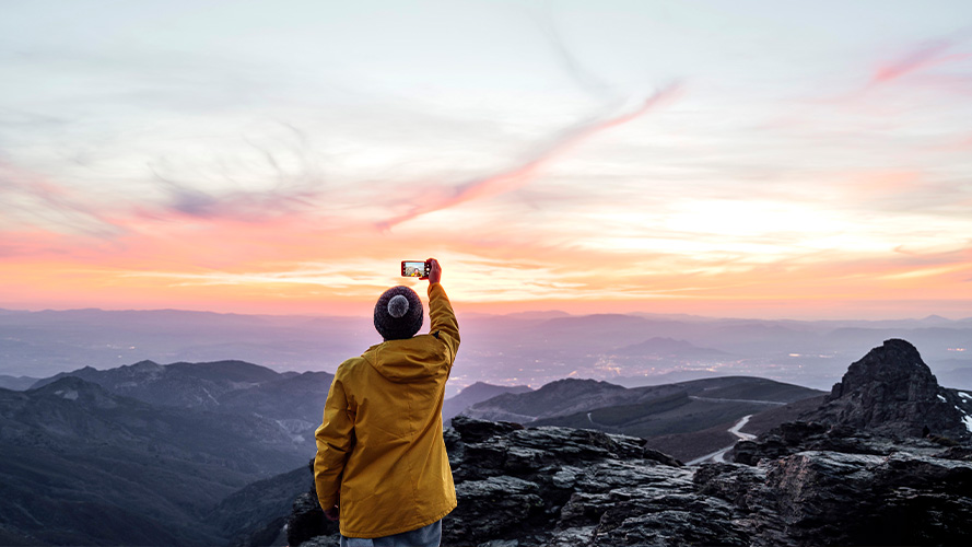 Man with open arms on the mountain peak